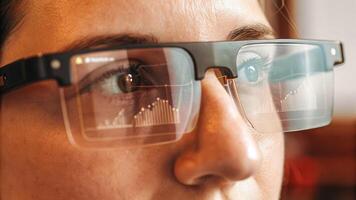 A closeup of a user wearing augmented reality glasses captivated by a vibrant hologram showcasing market trends and analytics in a modern office setting.. photo