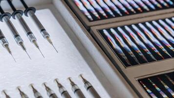 A detailed view of biohacker tools precision syringes and augmented reality display panels highlighting DNA sequences projected above them in vivid colors.. photo