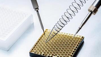Highresolution image of a handson assembly of a CRISPR geneediting setup showcasing intricate pipetting and DNA fragments on a specialized platform.. photo