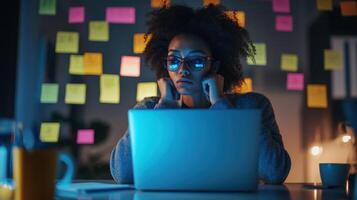A concentrated face illuminated by the blue light of a laptop showcasing a participant deep in thought surrounded by coffee cups and sticky notes filled with brainstorming ideas an photo