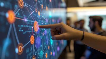 A closeup of a hand pointing to a visual aid on a screen displaying interconnected networks and potential vulnerabilities. The audience can be seen in the blurred background noddin photo