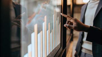A detailed view of a holographic bar graph vivid colors reflecting off a glass surface as a person points to specific datapoints with an intuitive hand gesture.. photo
