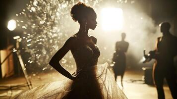 Fashion model posing during photoshoot with sparkling background and film crew photo