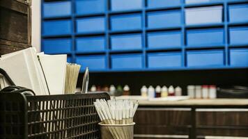 A closeup view of a workstation cluttered with pipettes Petri dishes and essential lab equipment set against a backdrop of modular shelving units stocked with colorful reagents and. photo