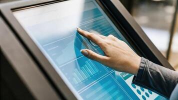 A closeup of a participants hand interacting with a touchscreen display that outlines personalized health biohacking strategies and data visualization.. photo