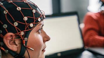 Closeup of a participants face focused and illuminated by the glow of a computer screen as they analyze their biometric data while wearing sensors and a headset measuring brain. photo