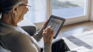 An older woman holds a DNA testing kit while consulting a digital tablet that analyzes her genetic information her expression thoughtful as she considers personalized health. photo