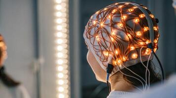 An artistic shot capturing the reflection of colorful LED lights on the EEG device while being worn creating an engaging visual overlay during the brain activity monitoring. photo