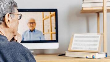 An elderly man seated in front of a computer watching an online seminar about epigenetics embodying a lifelong pursuit of knowledge and personal growth in understanding health and. photo