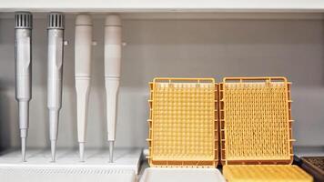 An array of advanced tools including a gel electrophoresis apparatus and fluorescent imaging systems set against a backdrop of clean white laboratory surfaces.. photo