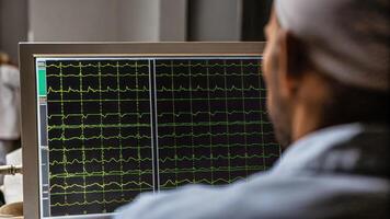 A technician observing a monitor filled with EEG data showcasing electrical patterns in the brain as they prepare to initiate a brain modulation session.. photo