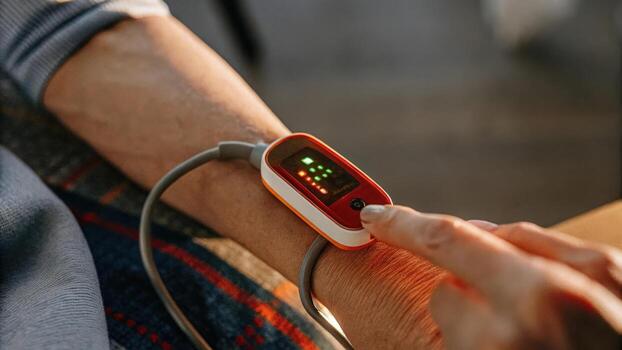 An artistic representation of a glowing pulse oximeter showing realtime oxygen saturation levels with vivid red and green hues depicting healthy versus low oxygen readings.. photo
