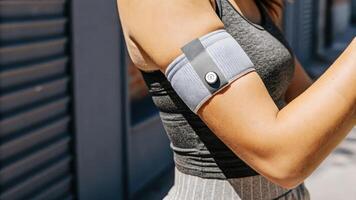 A models arm highlighting a chic fitness sleeve that includes skinembedded sensors for continuous glucose monitoring blending seamlessly with everyday athletic wear.. photo