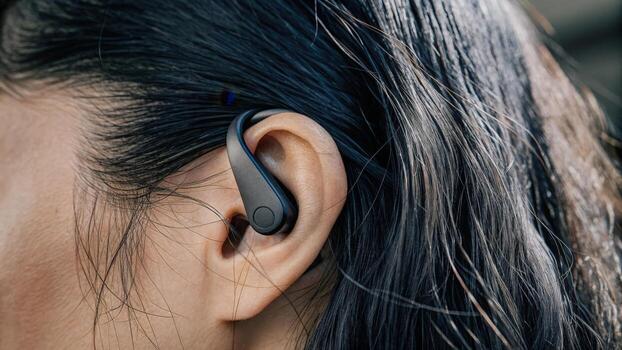 An earpiece equipped with a tiny biosensor that measures brainwave activity. The device blends seamlessly into the ear showcasing an intricate network of sensors and electrodes. photo