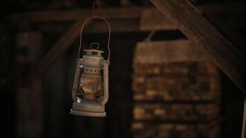 Rustic lantern hanging in an old barn illuminated by soft, warm light video