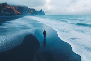 Solitude on Serene Black Sand Beach by Misty Cliffs at Ocean Wave Edge photo