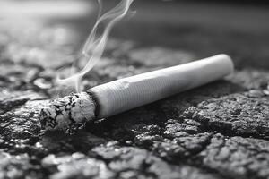 Smoking Concept Burning Cigarette on Asphalt for Anti-Smoking Campaign photo