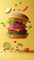 Delicious gourmet burger with fresh vegetables on yellow background photo
