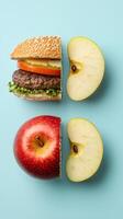 Creative food composition of burger and apple cut in half on blue background photo