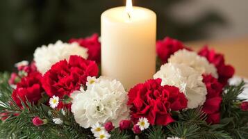 A candle is lit in a red and white arrangement photo