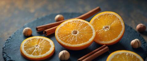 Fresh Orange Slices with Cinnamon Sticks and Hazelnuts on Dark Slate Surface for Healthy Recipe Ideas photo