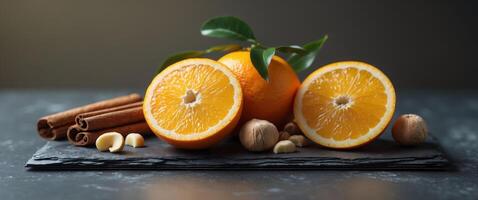 Fresh Orange Slices with Cinnamon Sticks and Hazelnuts on Dark Slate Surface for Healthy Recipe Ideas. photo