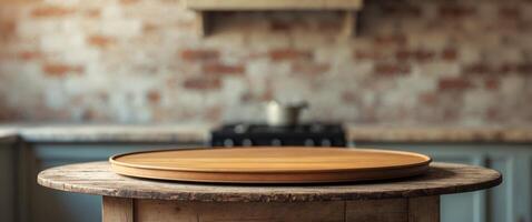 Empty round wooden tabletop on a wooden table with a blurred kitchen background and brick wall backdrop photo