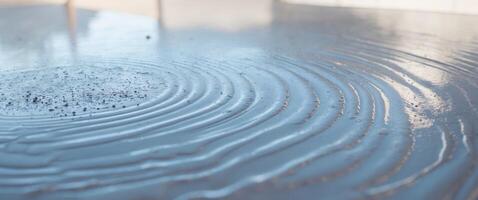 Wet cement with a glossy surface reflecting a bright background. photo