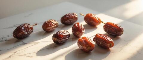 Fresh dates arranged on a marble surface showcasing rich colors of brown and red during a sunny afternoon photo
