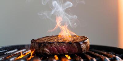 Sizzling juicy steak on a grill with flames and smoke creating a mouthwatering experience.Sizzling juicy steak on a grill with flames and smoke creating a mouthwatering experience. photo
