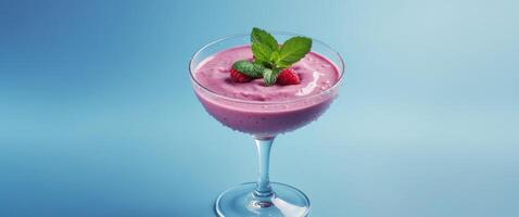 Refreshing berry smoothie with mint and ice served in a clear glass on a vibrant background. photo