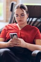 A businesswoman resting on a short break from work in a modern startup coworking center, using her smartphone to unwind and recharge. photo