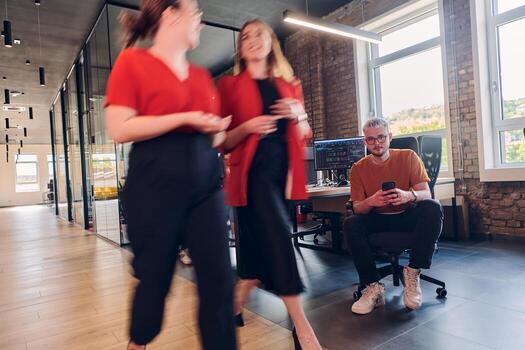 A diverse group of business professionals collaborates in a modern startup coworking center, utilizing a mix of paper-based and technological tools such as mobile phones and computers to collectively photo