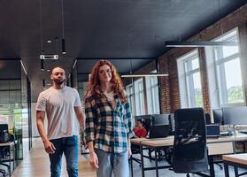 A young African American businessman and a modern businesswoman with orange hair stand side by side, arms crossed, exuding confidence and unity in a contemporary office setting, epitomizing dynamic photo