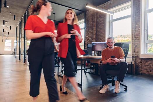 A diverse group of business professionals collaborates in a modern startup coworking center, utilizing a mix of paper-based and technological tools such as mobile phones and computers to collectively photo