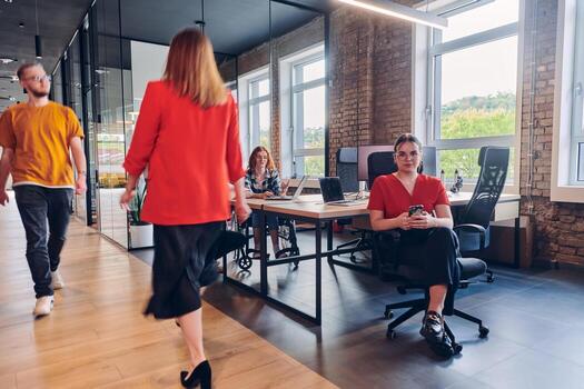 A diverse group of business professionals collaborates in a modern startup coworking center, utilizing a mix of paper-based and technological tools such as mobile phones and computers to collectively photo