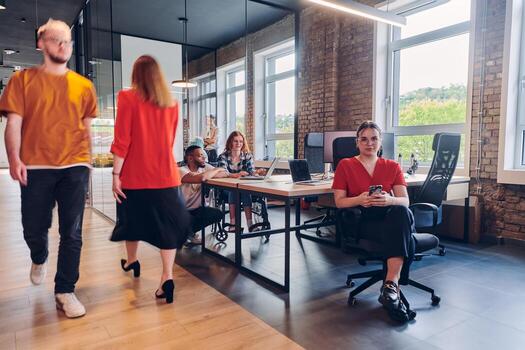 A diverse group of business professionals collaborates in a modern startup coworking center, utilizing a mix of paper-based and technological tools such as mobile phones and computers to collectively photo