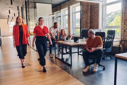 A diverse group of business professionals collaborates in a modern startup coworking center, utilizing a mix of paper-based and technological tools such as mobile phones and computers to collectively photo