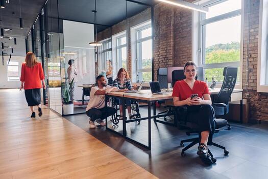 A diverse group of business professionals collaborates in a modern startup coworking center, utilizing a mix of paper-based and technological tools such as mobile phones and computers to collectively photo