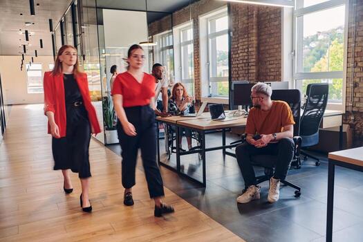 A diverse group of business professionals collaborates in a modern startup coworking center, utilizing a mix of paper-based and technological tools such as mobile phones and computers to collectively photo