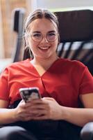 A businesswoman resting on a short break from work in a modern startup coworking center, using her smartphone to unwind and recharge. photo