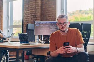 A modern businessman takes a relaxing break from work, using his smartphone to unwind and recharge during his pause photo