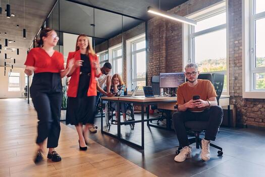 A diverse group of business professionals collaborates in a modern startup coworking center, utilizing a mix of paper-based and technological tools such as mobile phones and computers to collectively photo