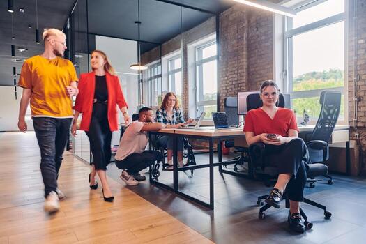 A diverse group of business professionals collaborates in a modern startup coworking center, utilizing a mix of paper-based and technological tools such as mobile phones and computers to collectively photo