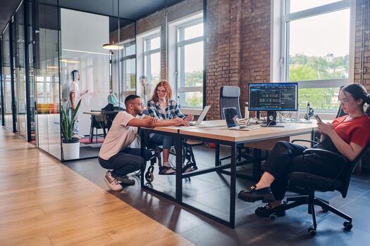 A diverse group of business professionals collaborates in a modern startup coworking center, utilizing a mix of paper-based and technological tools such as mobile phones and computers to collectively photo