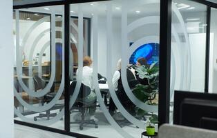 A diverse group of businessmen collaborates and tests a new virtual reality technology, wearing virtual glasses, showcasing innovation and creativity in their futuristic workspace photo