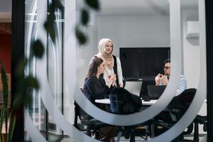 A diverse group of businessmen collaborates and tests a new virtual reality technology, wearing virtual glasses, showcasing innovation and creativity in their futuristic workspace photo