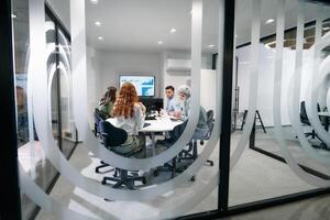 A diverse group of businessmen collaborates and tests a new virtual reality technology, wearing virtual glasses, showcasing innovation and creativity in their futuristic workspace photo