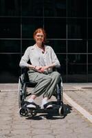 In front of a modern corporate building, a young woman sitting in a wheelchair confidently, symbolizing empowerment, inclusivity, and the strength to overcome challenges in the business world photo