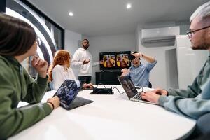 A diverse group of businessmen collaborates and tests a new virtual reality technology, wearing virtual glasses, showcasing innovation and creativity in their futuristic workspace photo